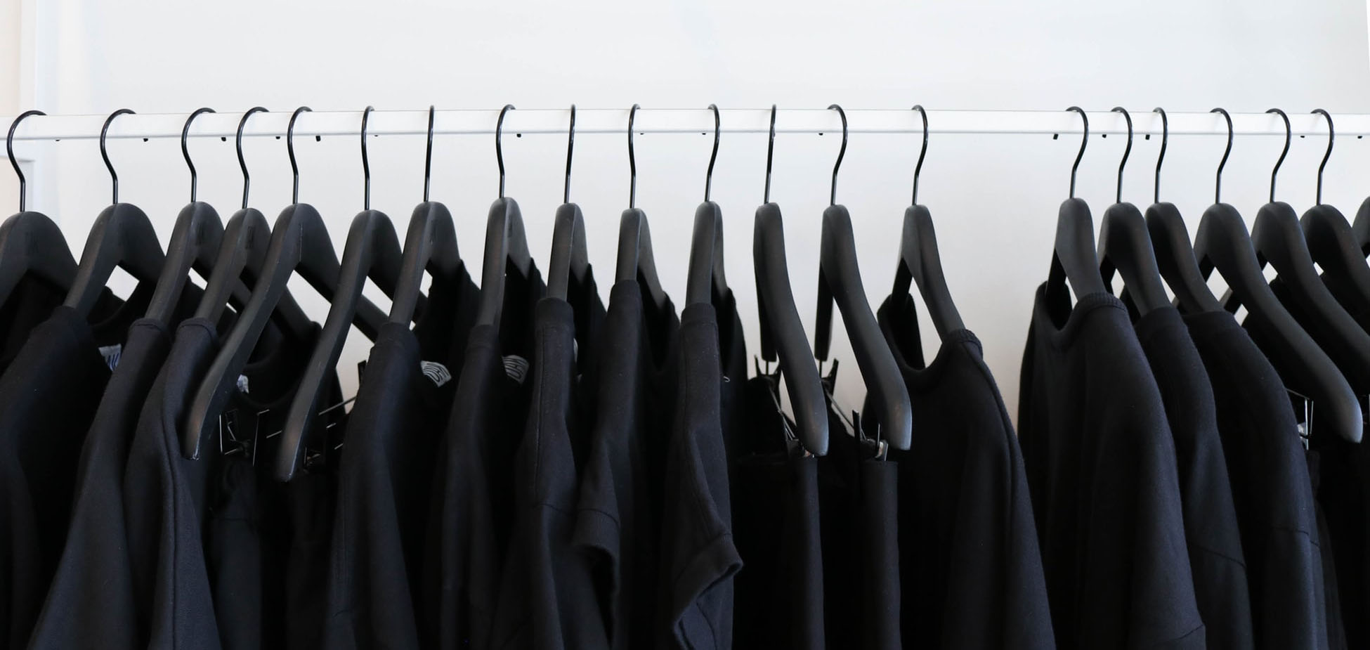photos de vêtements noirs accrochés sur un cintre